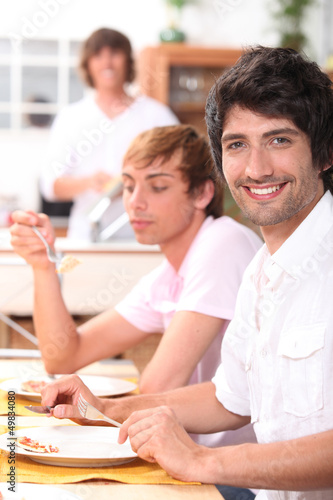 Photo: Young men eating a meal Young men eating a meal