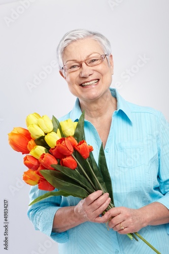 Photo: Grandmother with flowers smiling Grandmother with flowers smiling