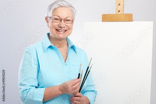 Photo: Old lady with paintbrush and canvas Old lady with paintbrush and canvas