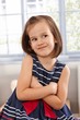Impish little girl smiling arms crossed
