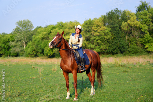 Photo: pretty young cowgirl riding horse pretty young cowgirl riding horse