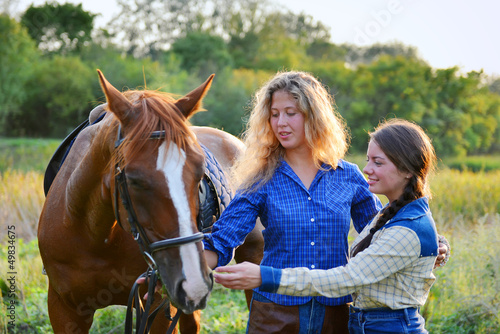 Photo: Two Beautiful Smiling Cowgirls with horse Two Beautiful Smiling Cowgirls with horse
