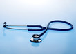 Pills and stethoscope on blue background