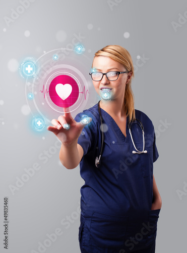 Photo: Young nurse pressing modern medical type of buttons Young nurse pressing modern medical type of buttons