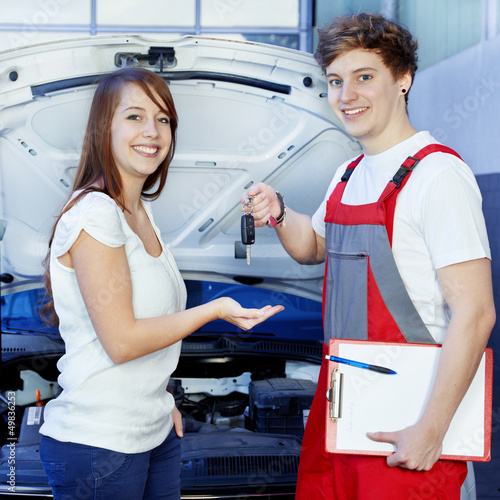 Photo: Key delivery between customer and mechanic in front of a car Key delivery between customer and mechanic in front of a car