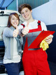 Car mechanic and customer in garage show thumbs up
