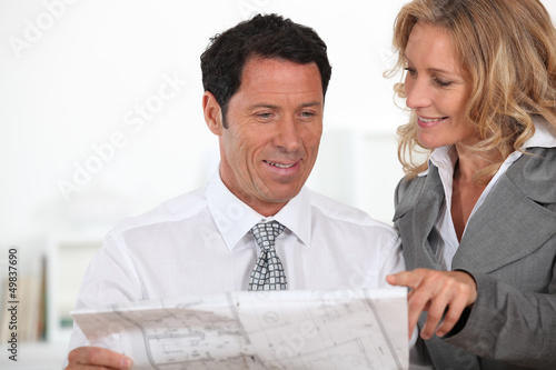 Photo: business partners looking at plans business partners looking at plans