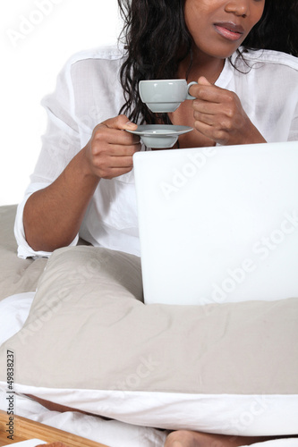 Photo: African woman drinking her coffee in bed African woman drinking her coffee in bed