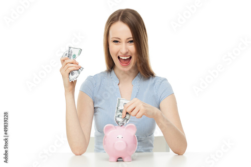 Photo: Woman putting money in piggy bank Woman putting money in piggy bank