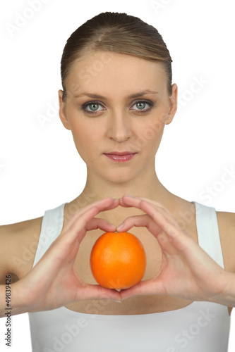 Photo: Woman holding an orange Woman holding an orange