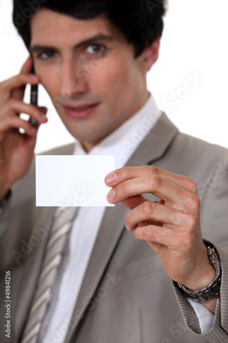 Photo: handsome businessman showing business card handsome businessman showing business card