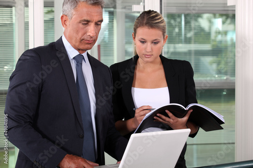 Photo: businessman and his young assistant working in the office businessman and his young assistant working in the office
