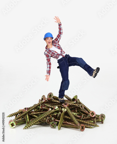Photo: Woman balancing on pile of screws Woman balancing on pile of screws