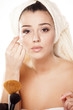 girl with towel on head fixes her makeup