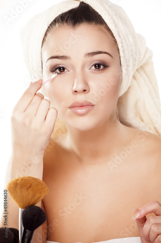 Photo: girl with towel on head fixes her makeup girl with towel on head fixes her makeup