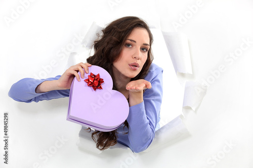 Photo: brunette holds box in shape of heart blowing a kiss brunette holds box in shape of heart blowing a kiss