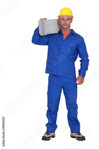 Photo: Builder carrying a concrete block Builder carrying a concrete block