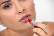 Woman applying red lipstick