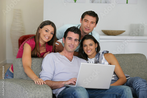 Photo: Four friends looking at photos on the computer Four friends looking at photos on the computer