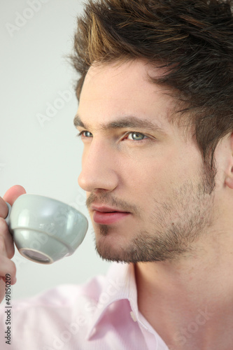 Photo: Young man drinking a cup of expresso Young man drinking a cup of expresso