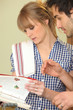couple looking for a recipe  in a cookbook