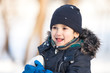 Cute boy playing with snow
