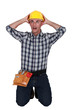 Astonished tradesman with his hands behind his head