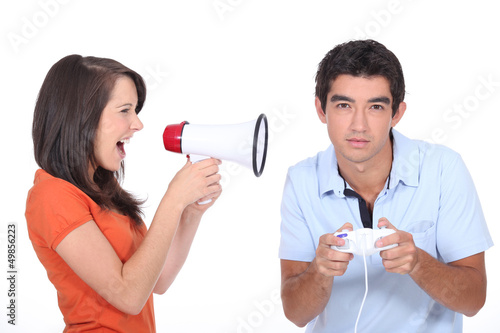 Photo: Girl screaming into megapgone whilst boyfridnd plays vide games Girl screaming into megapgone whilst boyfridnd plays vide games