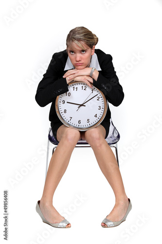 Photo: Upset woman sat with clock Upset woman sat with clock