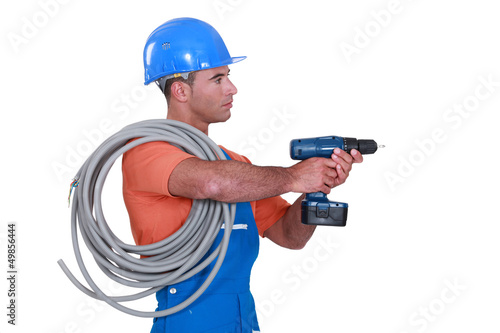 Photo: A handyman holding a drill. A handyman holding a drill.