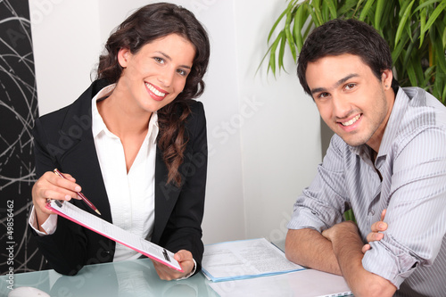 Photo: Woman explaining contract to customer Woman explaining contract to customer