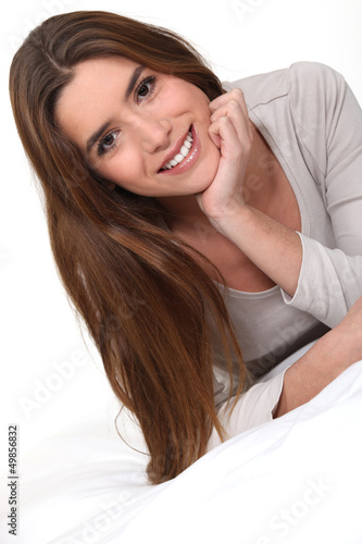 Photo: Young woman laid on a bed Young woman laid on a bed