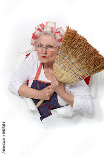 Photo: angry senior woman with curlers in her hair holding a broom angry senior woman with curlers in her hair holding a broom