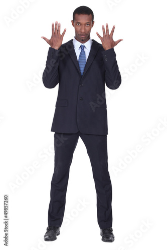 Photo: Studio shot of a business man with his hands in the air Studio shot of a business man with his hands in the air