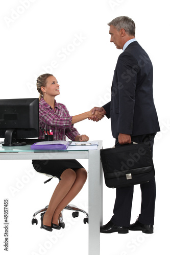 Photo: Businessman shaking hands with his new secretary Businessman shaking hands with his new secretary