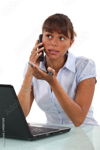 Photo: Brunette office worker at her desk Brunette office worker at her desk