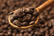 Coffee beans in wooden spoon, close up