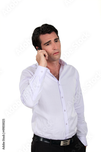 Photo: A sad businessman over the phone. A sad businessman over the phone.