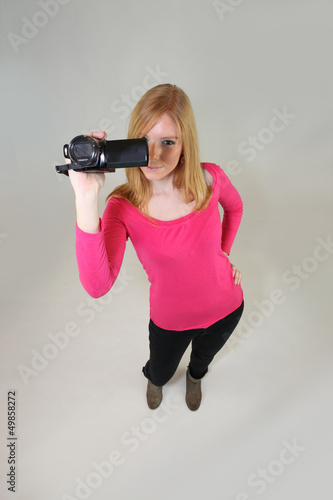 Photo: Young woman holding a video camera Young woman holding a video camera