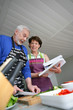 Foto: Mature couple cooking with cookbook Mature couple cooking with cookbook