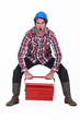 Worker struggling to lift tool box