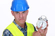 Angry foreman holding alarm clock