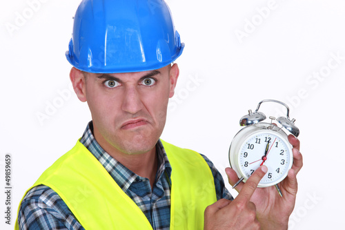 Photo: Angry foreman holding alarm clock Angry foreman holding alarm clock