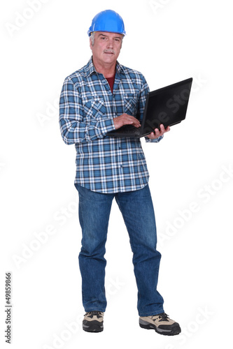 Photo: Tradesman holding a laptop Tradesman holding a laptop
