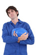 Construction worker holding his helmet to his chest