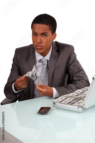 Photo: Shady businessman with luggage full of bills Shady businessman with luggage full of bills