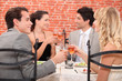 Foto: Friends raising their glasses in a toast at a restaurant Friends raising their glasses in a toast at a restaurant