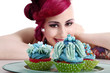 Photo: Junge Frau im Pin Up Style dekoriert verspielt Cupcakes Junge Frau im Pin Up Style dekoriert verspielt Cupcakes