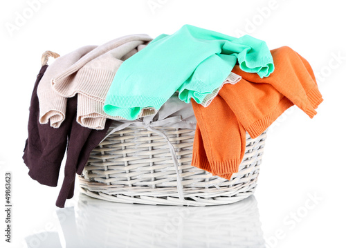 Photo: Clothes in wooden basket isolated on white Clothes in wooden basket isolated on white