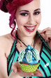 Photo: Junge Frau mit Zahnspange serviert lachend Cupcake Junge Frau mit Zahnspange serviert lachend Cupcake